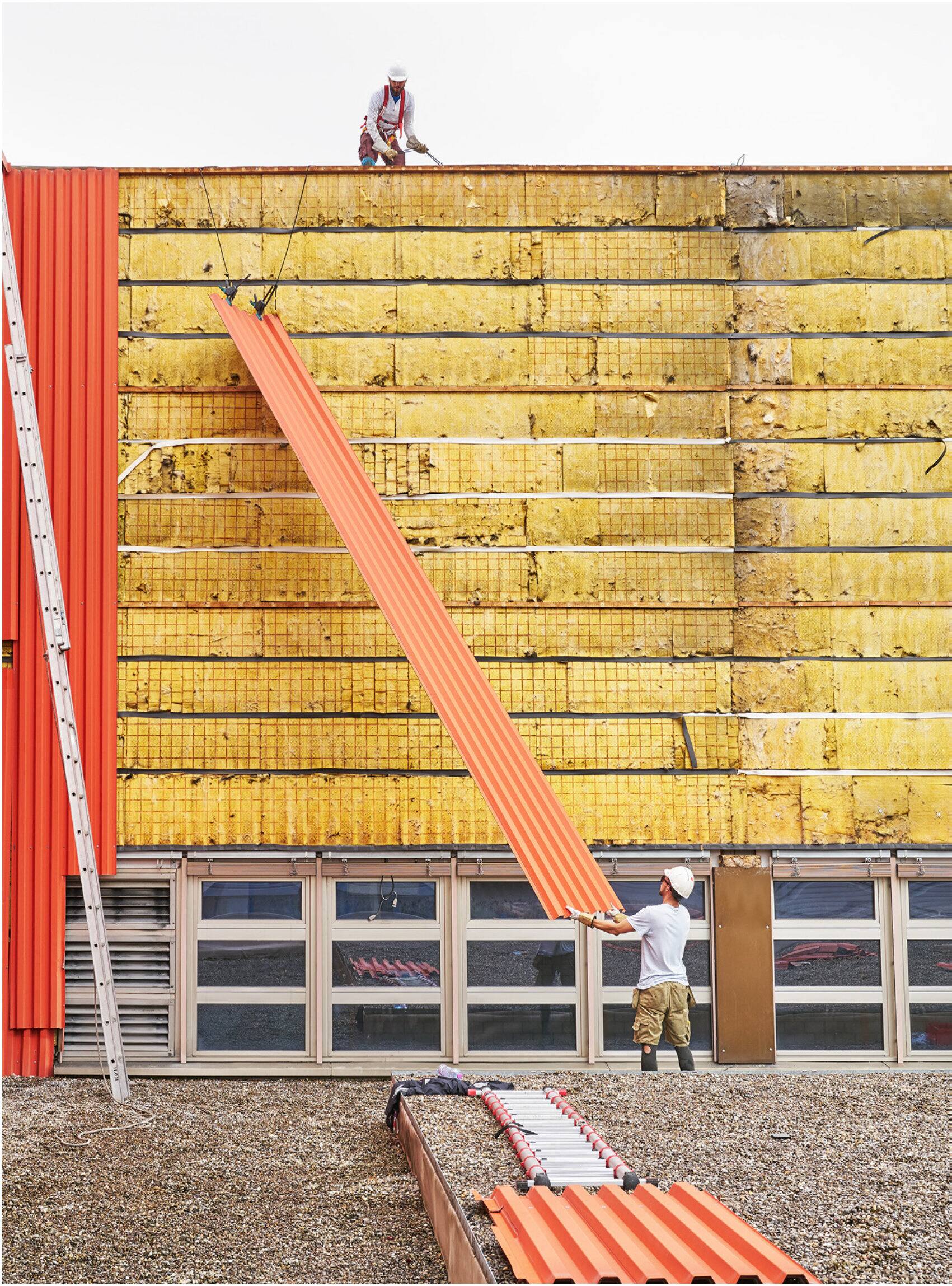 Ernte von Trapezblechen an einer Fassade mit freigelegter Dämmung